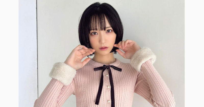 野口衣織のピンクのニットに黒のリボンの服の写真