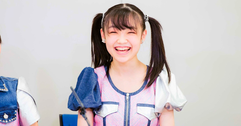 ツインテールの衣装姿の山崎愛生が満面の笑顔でカメラに向かって笑っている様子」