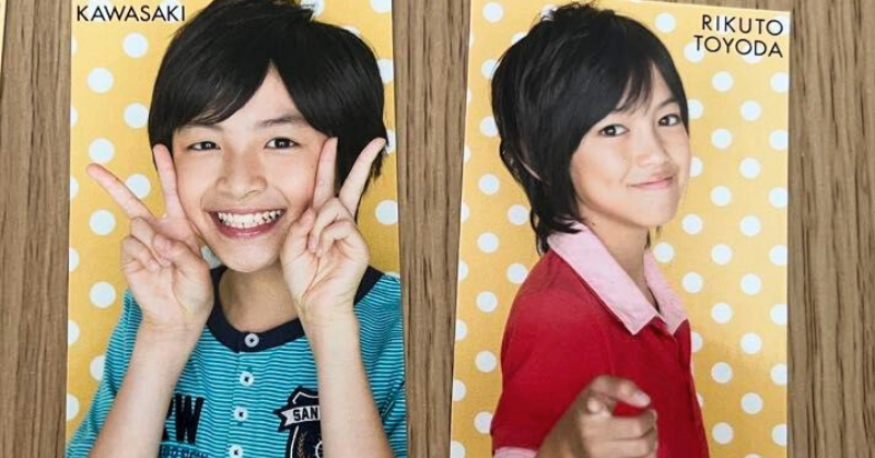 黄色の水玉背景の前でポーズを取る2人の男の子。左の川﨑皇輝は両手でピースをして笑顔、右の豊田陸人は赤いシャツを着て指差しポーズをしている