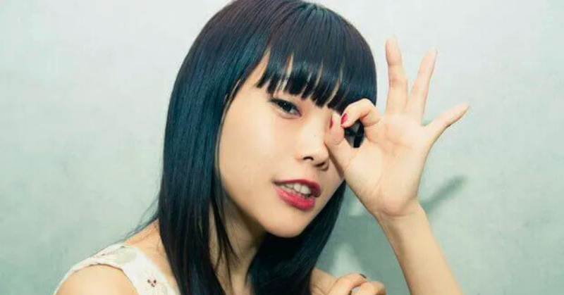 アイナジエンドが片手でOKポーズを作り、片目に当てたユニークな仕草のアップ写真。前髪ぱっつんとナチュラルメイクが印象的な画像