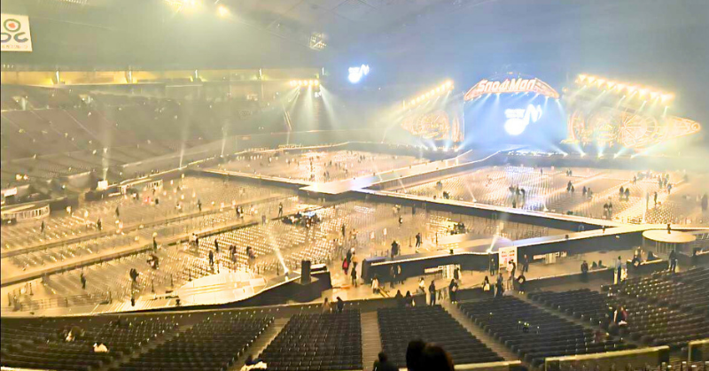 Snow Manのロゴが映し出された巨大ステージを中心に、観客が少しずつ退場している札幌ドームのライブ会場。照明が残る中、客席はまばらになっており、終演直後の様子がうかがえる。