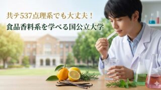 白衣の男性が香り紙を嗅いで香料を評価している。机の上にレモン（柑橘）、バニラビーンズ、ハーブと、色のついた液体が入ったビーカーが並び、背景に大学の校舎。画像上部に「共テ537点理系でも大丈夫！食品香料系を学べる国公立大学」の文字。