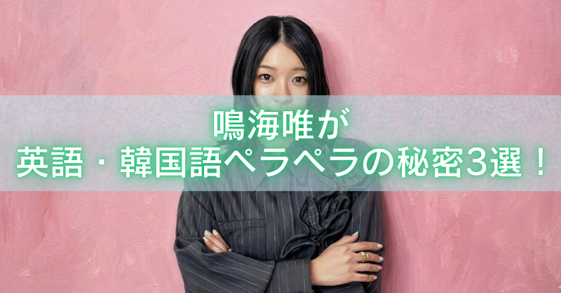 鳴海唯が英語と韓国語を話せる理由を解説する記事アイキャッチ、ピンクの壁の前で腕を組む鳴海唯
